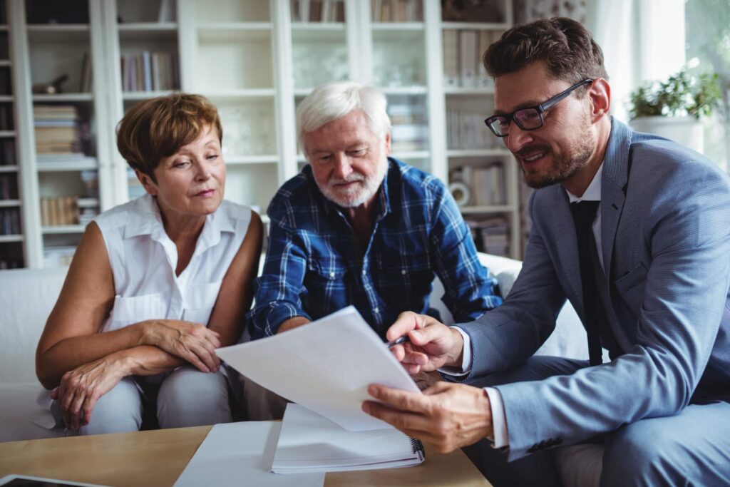 Older couple meeting with advisor in their home to discuss financial planning and RMD tax strategies.