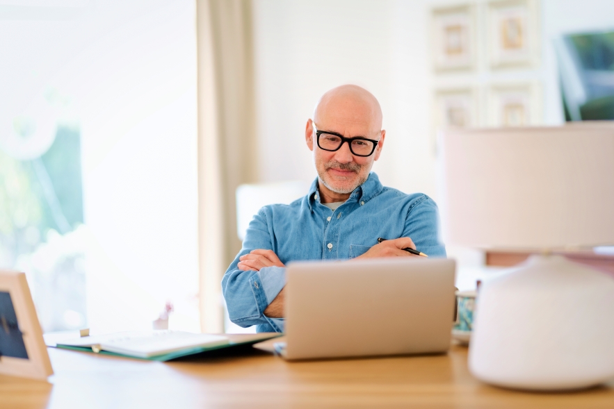 Man sitting at computer, reviewing the stock market in 2025