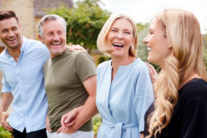 Parents walking and laughing with their adult children