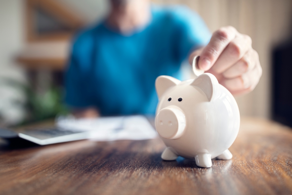 Person putting money in piggy bank