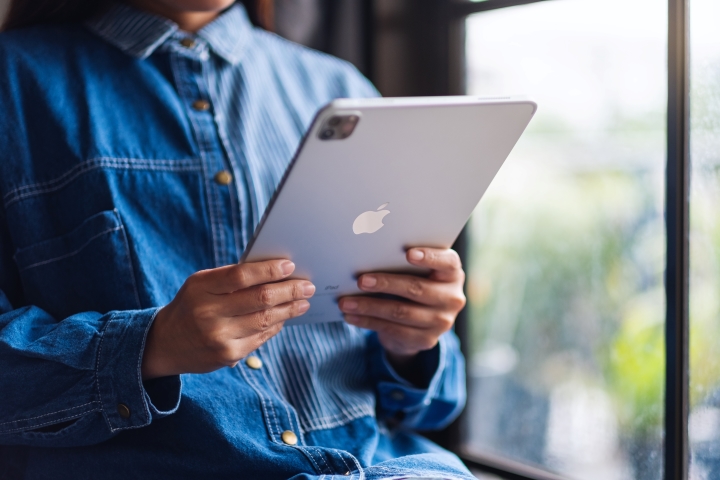 Person reviewing investment news on iPad